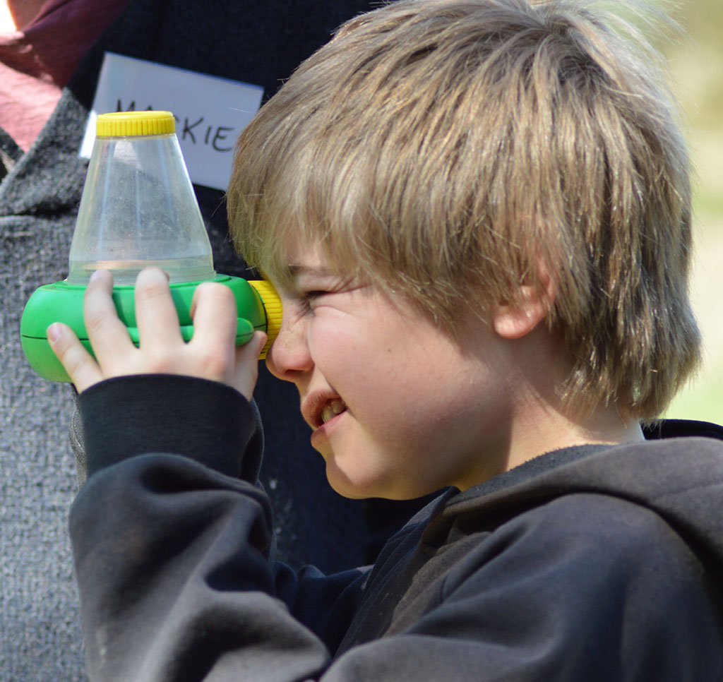 boy using a gadget to examine a specimen